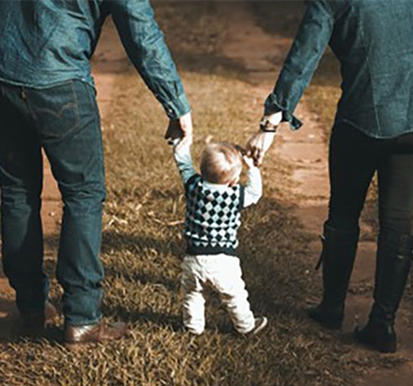 Couple walking hand in hand with their small children