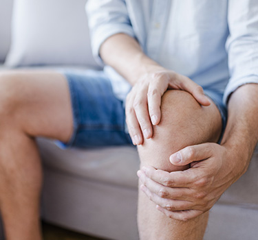 Older man dealing with knee pain and joint inflammation