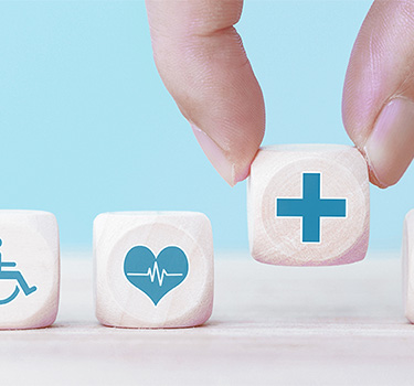 Five white dice showing icon pictures of water, health and disabilities