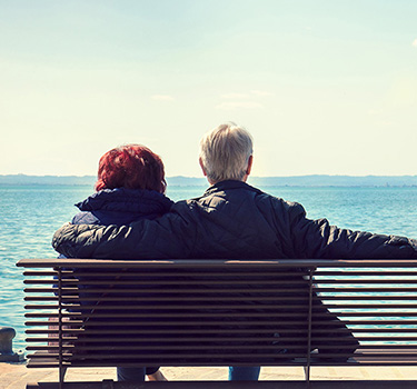 Senior couple on bench by the water