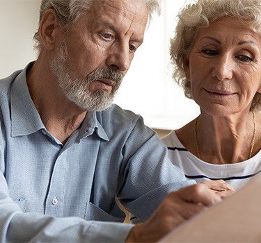 Older couple reviewing a document in their living room