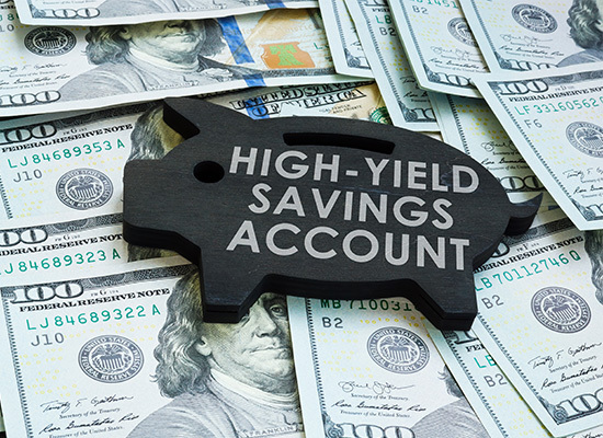 money with a wooden piggy bank on top labeled high-yield savings account