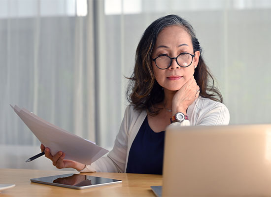 lady at a table with a laptop and papers, goin over retirement benefits