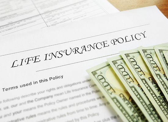 A close-up of a life insurance policy document with American dollar bills, emphasizing the financial aspects and agreements involved in life insurance.