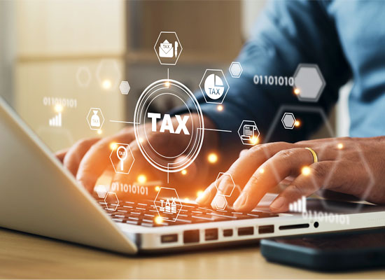Person typing on a laptop with digital tax icons