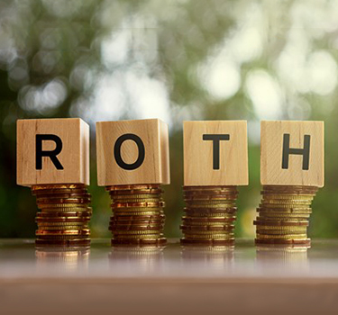 Roth in wooden block letters sitting on top of coins