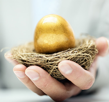 Man holding a golden egg in a small birdnest