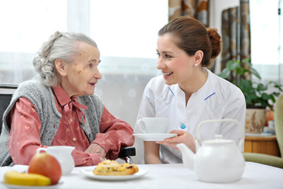 Senior woman receiving meal from in home carer