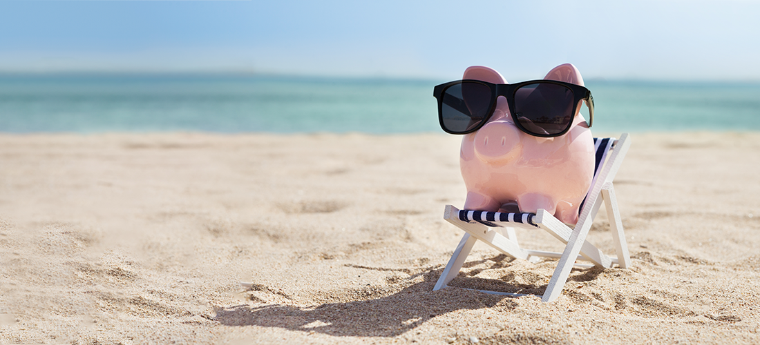Piggy bank on a chair at the beach relaxing