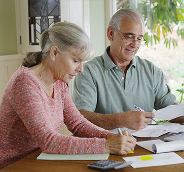 a senior couple reviewing their debt to try to make it disappear