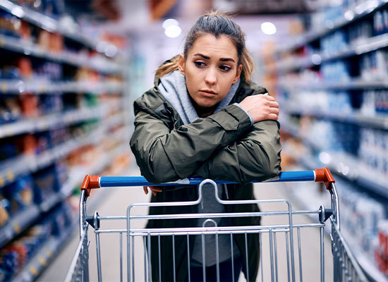 person shopping leaning on buggy unamused by pricing