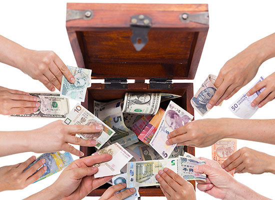 a wooden box with money from different countries being placed inside