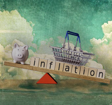 The image depicts a balancing scale with a piggy bank on one side and a shopping basket on the other, with the word 'inflation' spelled out in wooden blocks, symbolizing the impact of inflation on savings and purchasing power.