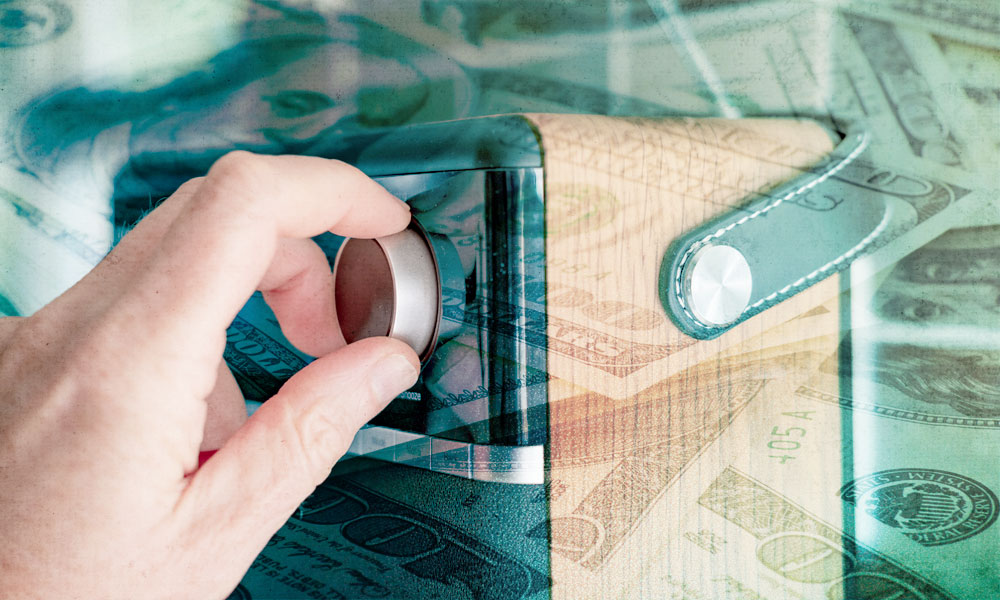 Hand adjusting a safe dial overlayed with dollar bills, symbolizing retirees managing retirement savings