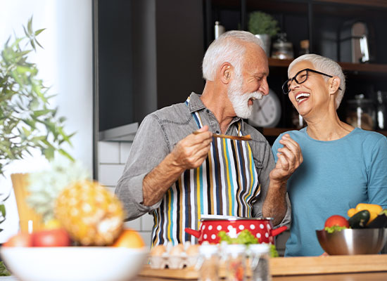 A senior couple in a kitchen cooking a healthy meal
