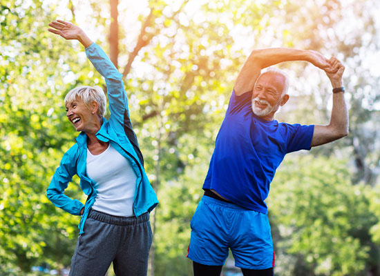 a senior couple performing stretches together