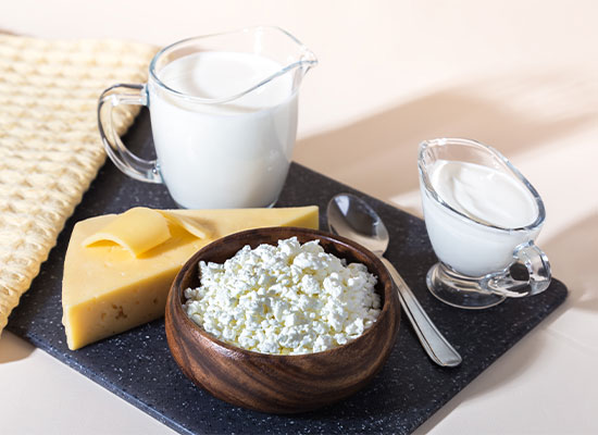 a platter containing cottage cheese, cheddar cheese, and milk