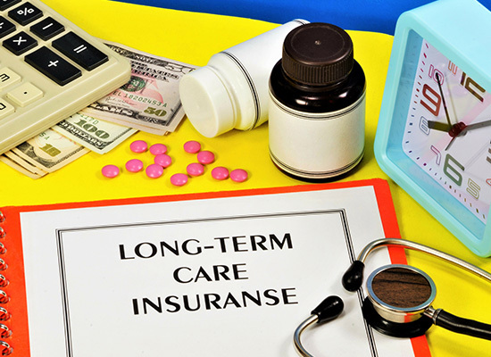 medicine, stethascope, money and a long-term care insurance booklet