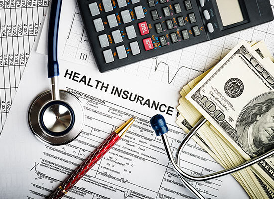 health insurance form with money, a calculator and pen