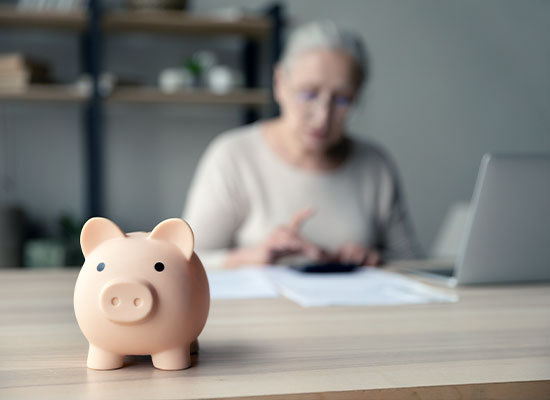 piggy bank with woman looking at cost of memory care