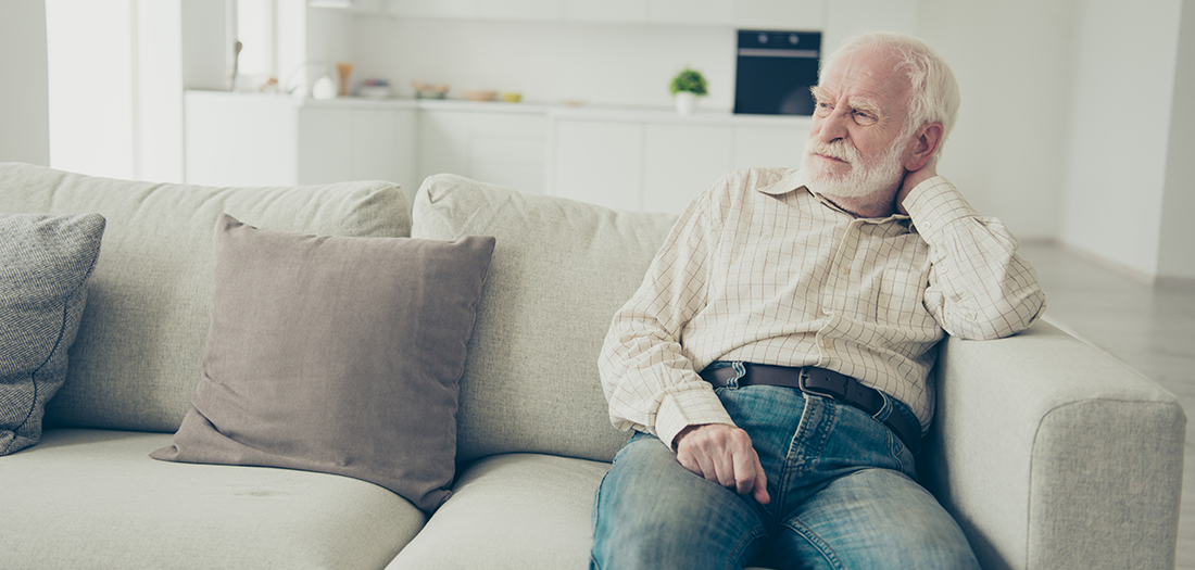 Older man sitting alone on his couch during social isolation
