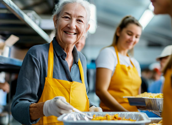 A smiling retiree wearing an apron demonstrates the benefits of volunteering for healthy aging and social engagement during retirement.