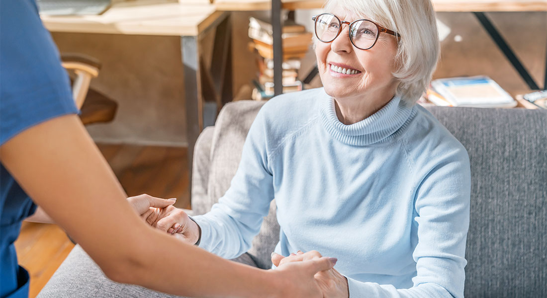 Happy older American woman holding hands with caregiver