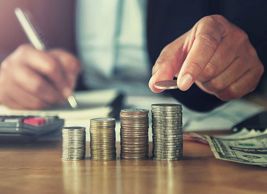 person stacking and adding up coins