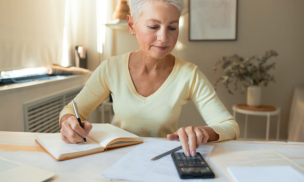 woman at desk with calculator going over income