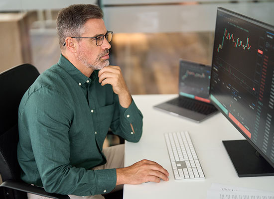 man looking at stock graph on computer screen