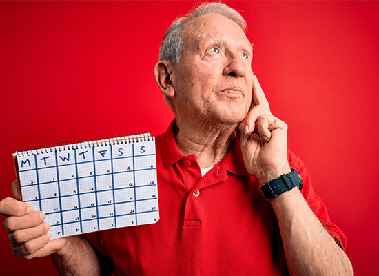 elderly man holding a calendar
