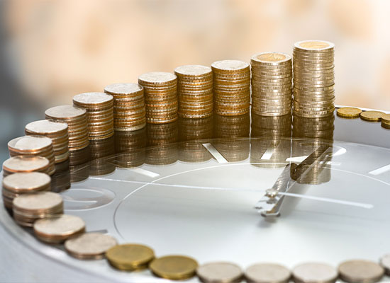 Stacks of coins arranged in ascending order on a reflective clock face, creating a circular pattern reminiscent of estate planning strategies.