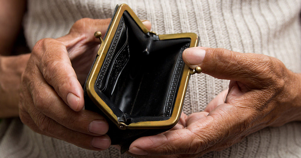 Elder woman's hands opening an empty coin purse