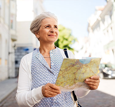 A woman holding a map in a city.