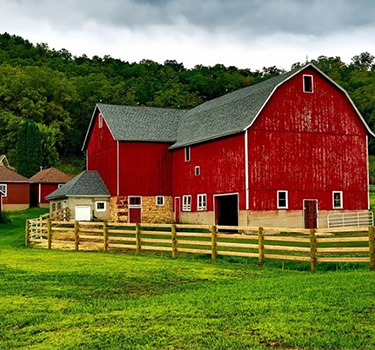 Large plot of farmland centered around a big red farm barn