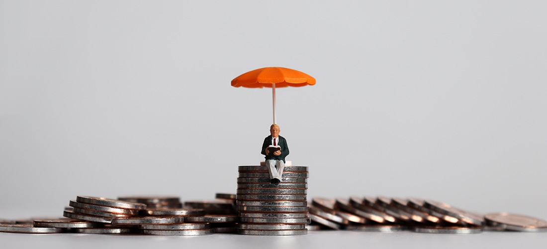 Toy figurine of a man sitting on stack of coins