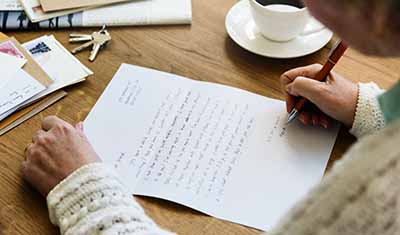 Old woman writing letter to her pen pal