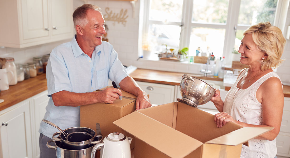 an older couple packing away a few kitchen items to help a parent or grandparent downsize