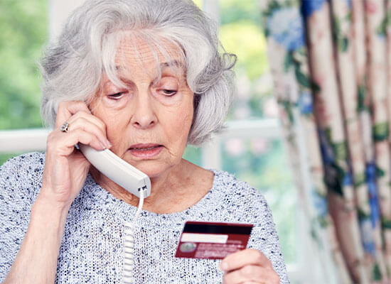 Elderly woman checkin her accounts over the phone