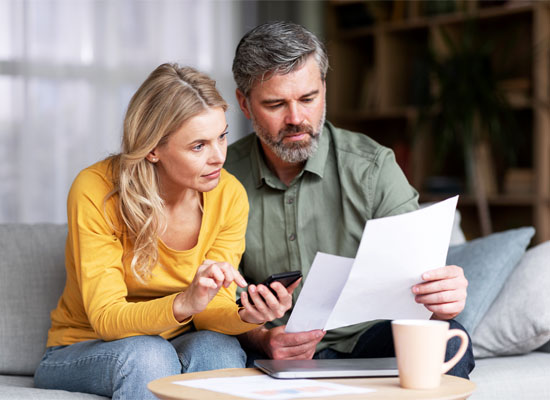 A couple at retirement age reviewing financial documents together, focusing on estate planning, financial protection, and inheritance rights in a late-life