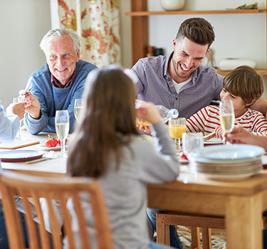 Happy multigenerational family living together, having breakfast
