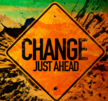A vibrant road sign reading 'Change Just Ahead' set against a textured, colorful background symbolizing transformation and new opportunities.