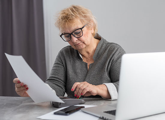 An older woman reviewing her tax returns for inefficiencies 