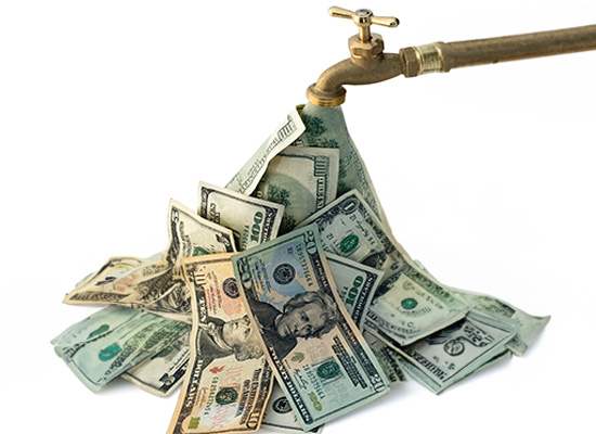 A faucet dripping U.S. dollar bills into a pile, illustrating the concept of steady cash flow or income.